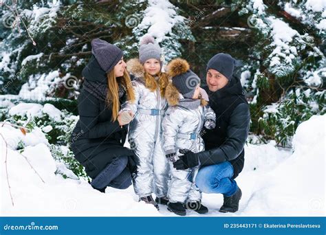 famiglia vestita con abbigliamento invernale e neonato nel passeggino sulla neve