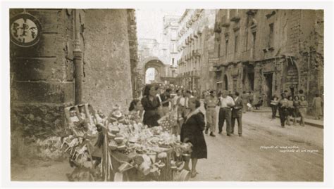 Una scena di Napoli nel dopoguerra, con edifici danneggiati e persone per strada