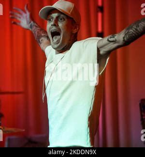 Aaron Carter che si esibisce sul palco durante un concerto, circondato da luci vivaci e una folla entusiasta