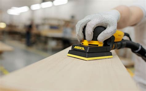 Levigatura di una superficie in legno con carta vetrata e blocchetto