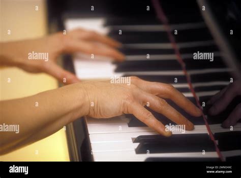 dettaglio di mani che suonano una melodia dolce su un pianoforte a coda