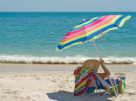 Una famiglia serena che trascorre una giornata al mare proteggendo la pelle con prodotti solari delicati