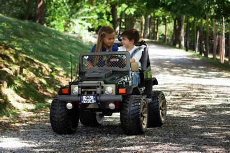 Bambini seduti comodamente a bordo di un fuoristrada Peg Perego con cinture allacciate