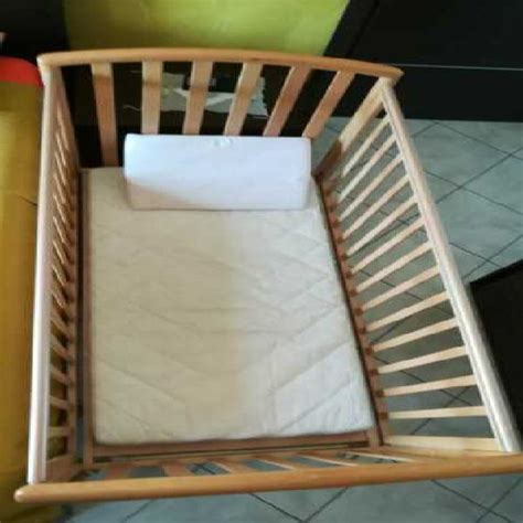 dettaglio ravvicinato di una culla artigianale con sponde a distanza regolamentare