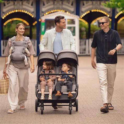 Famiglia con due bambini piccoli e passeggino doppio
