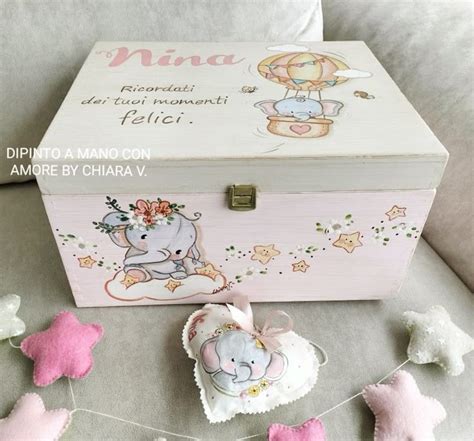 Scatola dei ricordi con un fiocco nascita, scarpine e altri oggetti d'infanzia