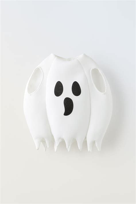 Bambino vestito da fantasma con torta di compleanno