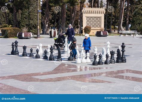 bambini che giocano a scacchi in un parco pubblico, concentrati sulla scacchiera