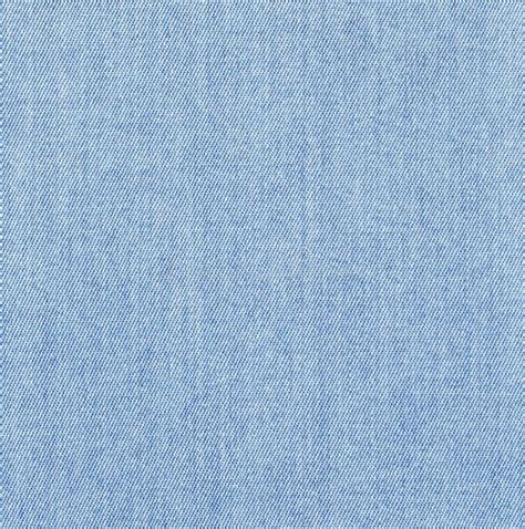 Dettaglio ravvicinato di diverse texture di denim, dal blu chiaro lavato al nero profondo, con focus sulle cuciture dei jeans a zampa