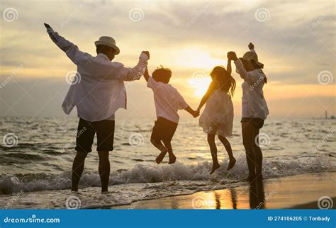 Famiglia felice su una spiaggia tropicale al tramonto