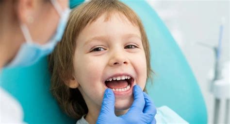 Un bambino sorridente che riceve un controllo dentistico in un ambiente accogliente e rassicurante