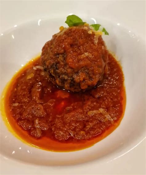 Dettaglio della consistenza interna di una polpetta al forno, umida e morbida