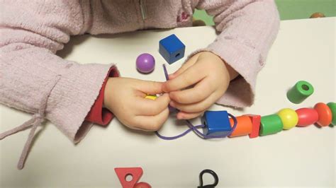 Bambini che infilano perline