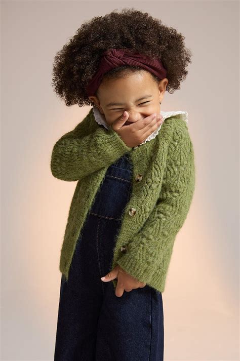 bambina che indossa un morbido cardigan colorato in un parco autunnale