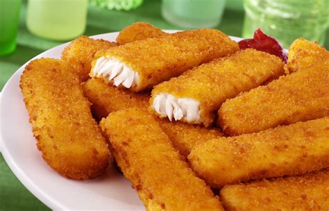 piatto con bastoncini di pesce dorati e croccanti serviti con una guarnizione di limone e prezzemolo