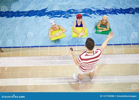gruppo di bambini che interagiscono durante una lezione di nuoto