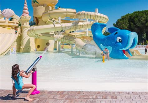 bambini che giocano in un parco acquatico immerso nel verde