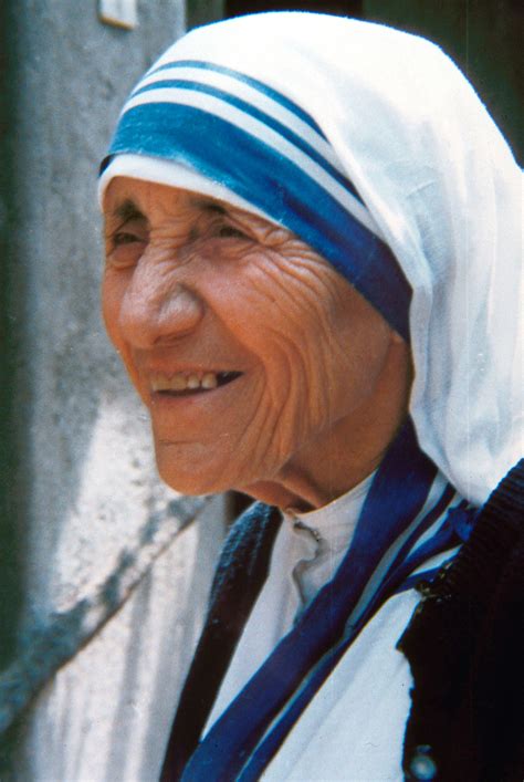 Fotografia d'epoca di Madre Teresa di Calcutta mentre accarezza un bambino con un sorriso radioso