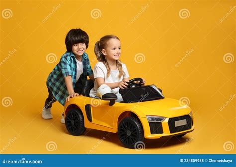 Bambini che giocano con una Mercedes giocattolo elettrica