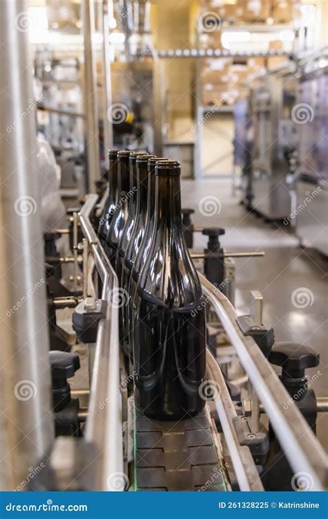 immagine di un impianto di imbottigliamento con bottiglie in vetro scuro