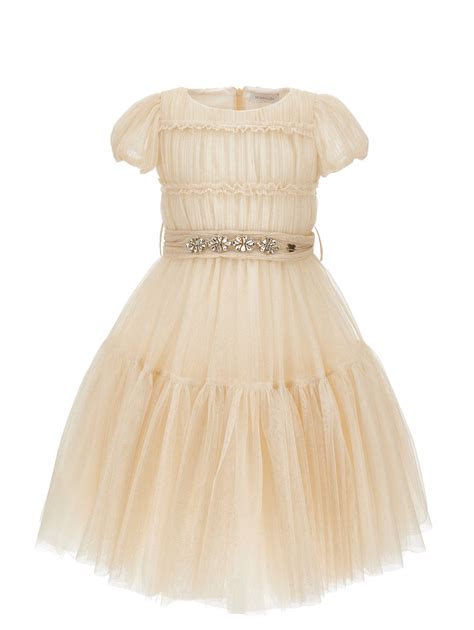 Bambina che indossa un abito in tulle elegante in un giardino fiorito