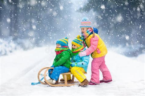 bambini che giocano sulla neve con bob colorati