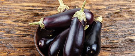 diverse varietà di melanzane disposte su un tavolo di legno