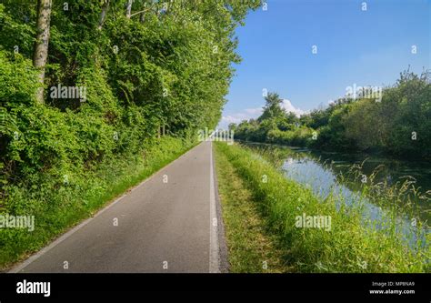 ciclisti su un percorso pianeggiante lungo il fiume Adda