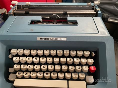 Una storica macchina da scrivere Olivetti poggiata su un tavolo di legno in uno studio d'epoca