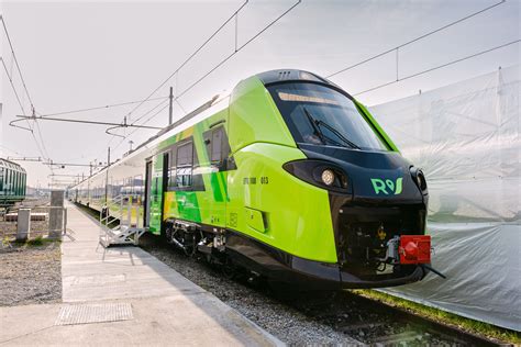 Treno regionale Trenord in transito in una stazione montana