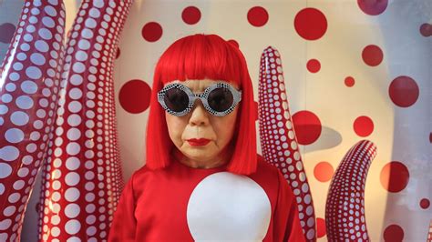 Ritratto di Yayoi Kusama circondata dai suoi iconici pois