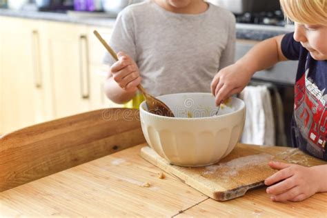 Bambini che cucinano con i genitori, sorridendo mentre mescolano ingredienti in una ciotola