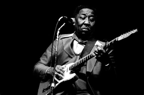 foto d'epoca di Muddy Waters con la sua chitarra elettrica a Chicago