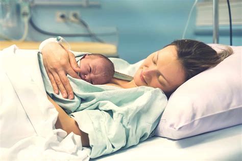 Madre che pratica il metodo canguro con il neonato