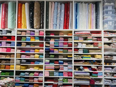 Tavolo da lavoro con tessuti, nastri e accessori di merceria disposti in ordine