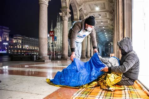 Immagine di volontari che distribuiscono cibo e coperte ai senzatetto