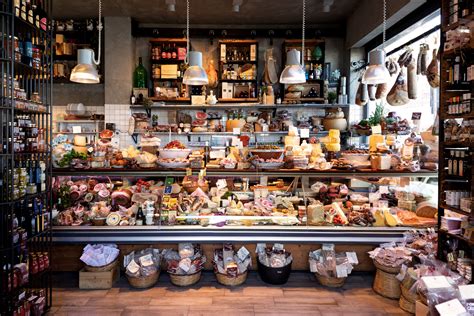 Interno di una salumeria gourmet con esposizione di prodotti freschi e formaggi