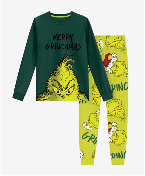 Bambino sorridente che indossa il pigiama del Grinch con motivo natalizio