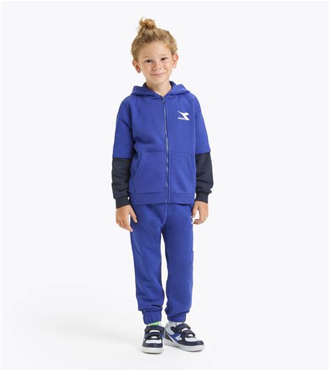bambino che corre in un parco indossando una tuta sportiva blu
