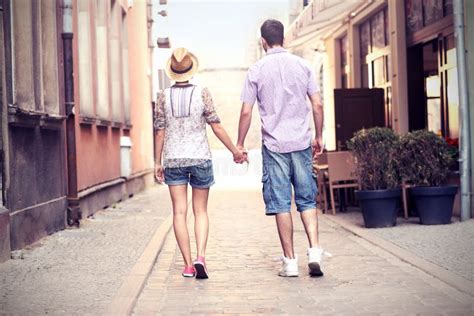Coppia famosa che passeggia sorridente in un contesto urbano