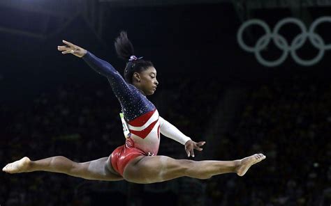 Simone Biles in una posa acrobatica durante una competizione internazionale