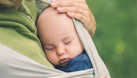 Genitore che abbraccia il neonato in fascia