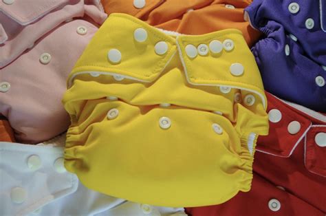 confronto visivo tra pile di pannolini usa e getta e set di pannolini lavabili colorati