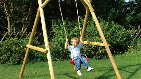 bambino piccolo su un'altalena sicura con schienale