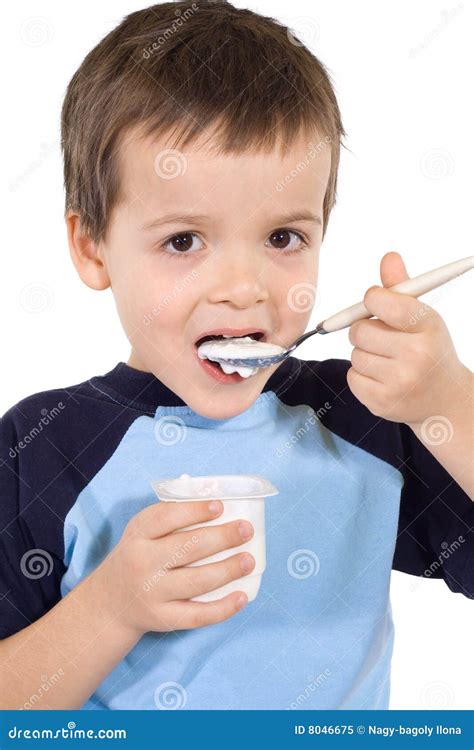 Bambino che mangia lo yogurt con un cucchiaino