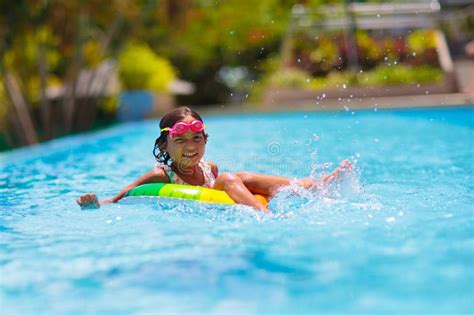 Bambino con costume contenitivo in piscina che gioca con l'acqua