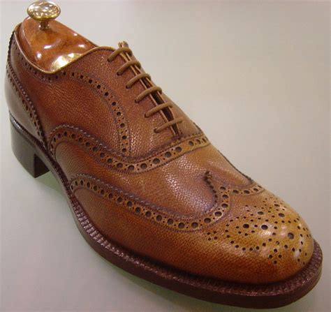 dettaglio di una scarpa oxford lavorata con broguing su un tappeto elegante