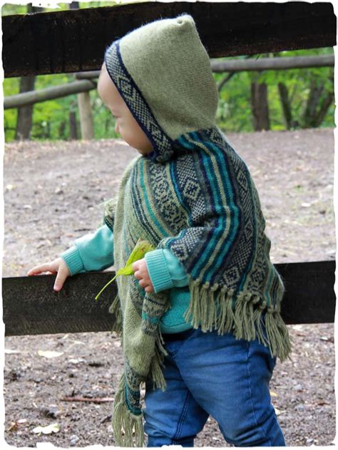 bambina che indossa un poncho di lana fatto a mano in un parco autunnale