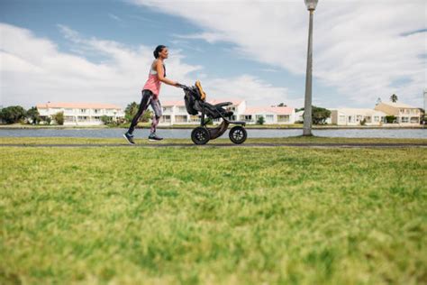 genitore che corre con un passeggino da running in un parco