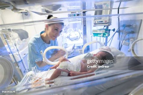Neonatologo che controlla un neonato in un'incubatrice per il trasporto